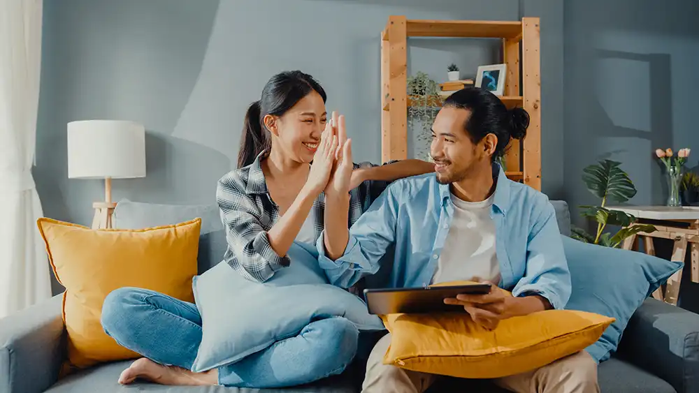 Happy Asian Young Attractive Couple Man Woman Sit Couch Use Tablet Shopping Online Furniture New House